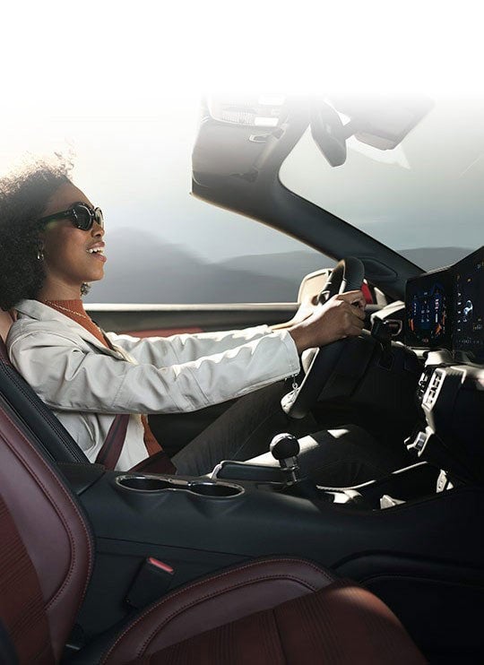 Person sitting in the driver’s seat of a 2024 Ford Mustang® convertible | Santee Ford in Manning SC